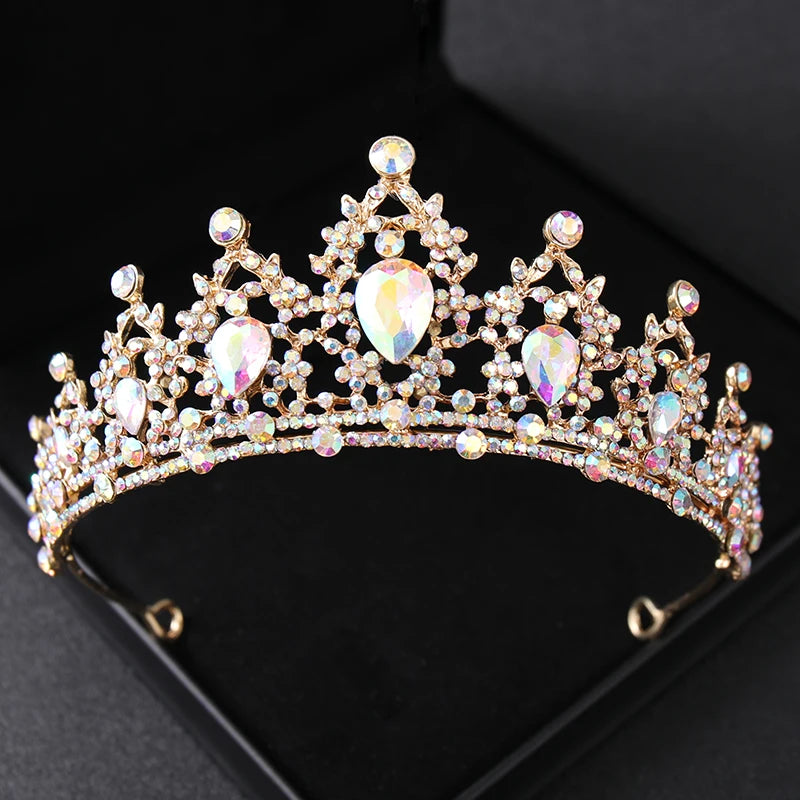 Couronne de diadème en cristal ton or avec des pierres scintillantes, présentée sur une boîte de velours noir.