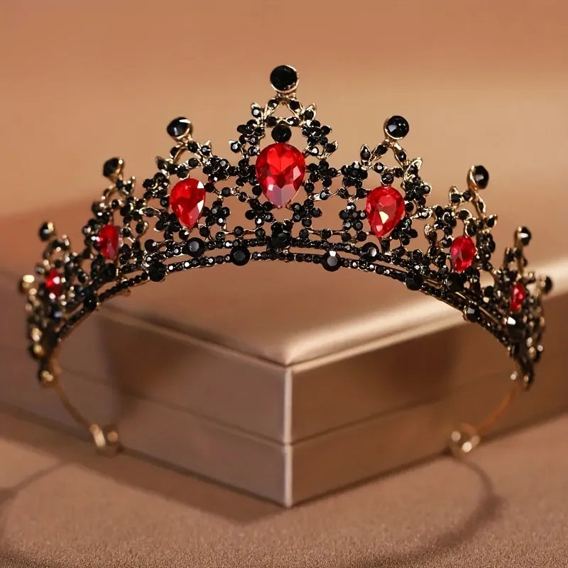 Diadema de cristal barroca negra y roja con intrincado diseño floral, exhibida en una caja de luz.