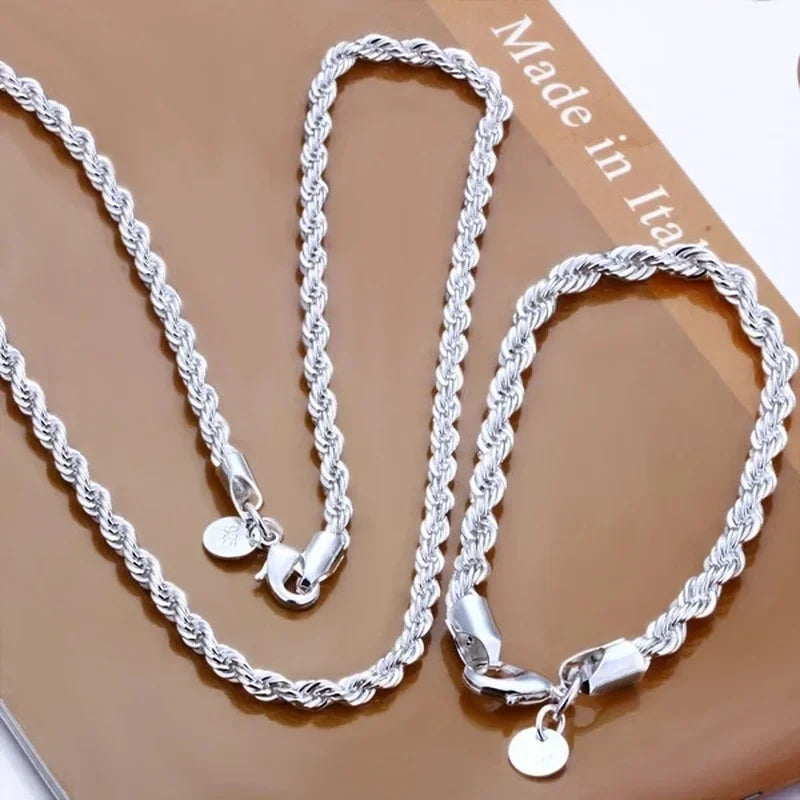 A set of twisted rope necklaces and bracelets made of 925 sterling silver displayed on a brown surface.