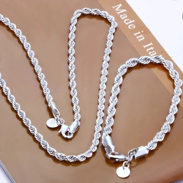 A set of twisted rope necklaces and bracelets made of 925 sterling silver displayed on a brown surface.