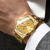 A close-up of a gold-toned stainless steel quartz watch worn on a wrist, paired with a white shirt and a textured jacket.
