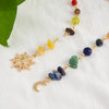 A delicate gold necklace featuring various colored gemstone beads and a sun moon pendant on a white background.