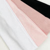 A stack of four knitted hair bands in white, pink, and black colors.