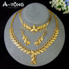 A set of luxury gold plated bridal jewelry featuring layered necklaces and floral pendants displayed on a stand.