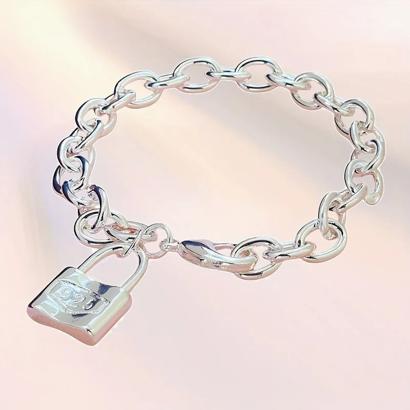 A silver charm lock bracelet made of 925 sterling silver with a chain link design.