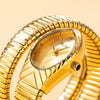 A close-up of a gold-toned ladies watch with a snake design on the strap and a clear crystal face.
