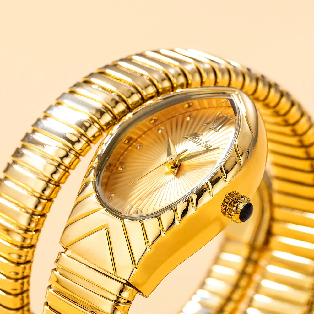 A close-up of a gold-toned ladies watch with a snake design on the strap and a clear crystal face.