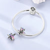 Sterling silver devil's eye charm bracelet with a silver clasp and a small charm featuring purple and pink glitter