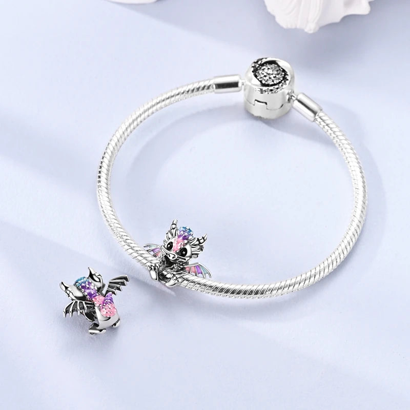 Sterling silver devil's eye charm bracelet with a silver clasp and a small charm featuring purple and pink glitter