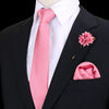 Chaqueta negra sobre camisa blanca y corbata de seda rosa a rayas con flor rosa