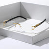 Trendy frameless rectangular sunglasses with gold accents resting in a white box.