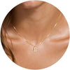 A close-up of a gold plated alphabet initial necklace with the letter E worn around the neck.