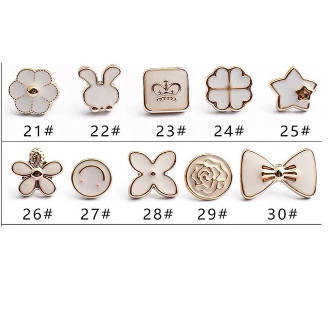 A collection of elegant button brooch pins featuring various shapes including leaves, crowns, stars, and floral designs.