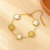 Gold plated stainless steel double-sided petal bracelet with white floral charms on a light background