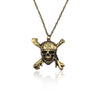 A gold-toned skull pendant necklace with a chain, featuring intricate detailing on the bone structure.