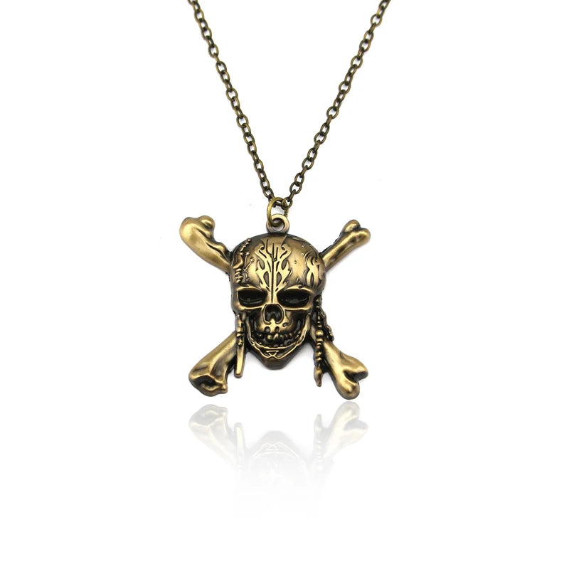 A gold-toned skull pendant necklace with a chain, featuring intricate detailing on the bone structure.