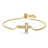 A gold plated cross bracelet featuring cubic zirconia stones, shown against a white background.