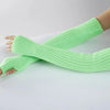 A hand wearing a light green knitted fingerless glove on the forearm.