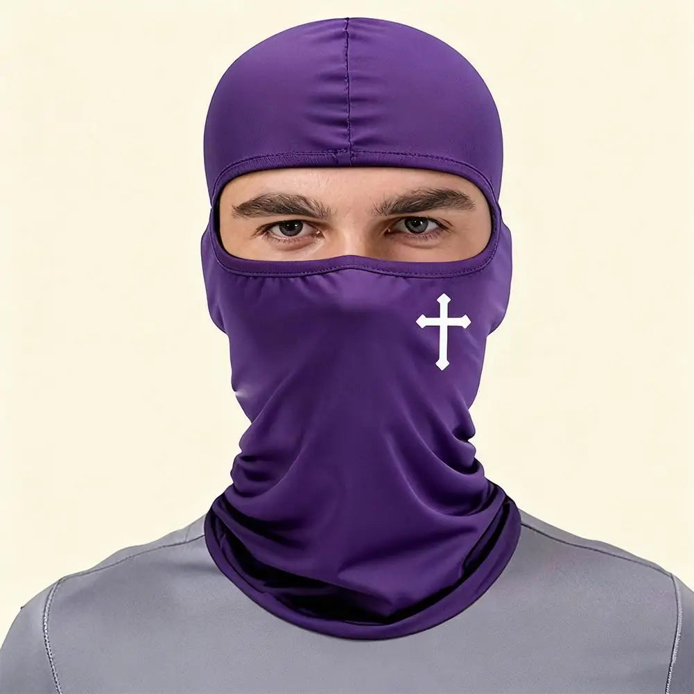 Modelo masculino vistiendo una máscara balaclava deportiva y de invierno morada con diseño de cruz blanca.