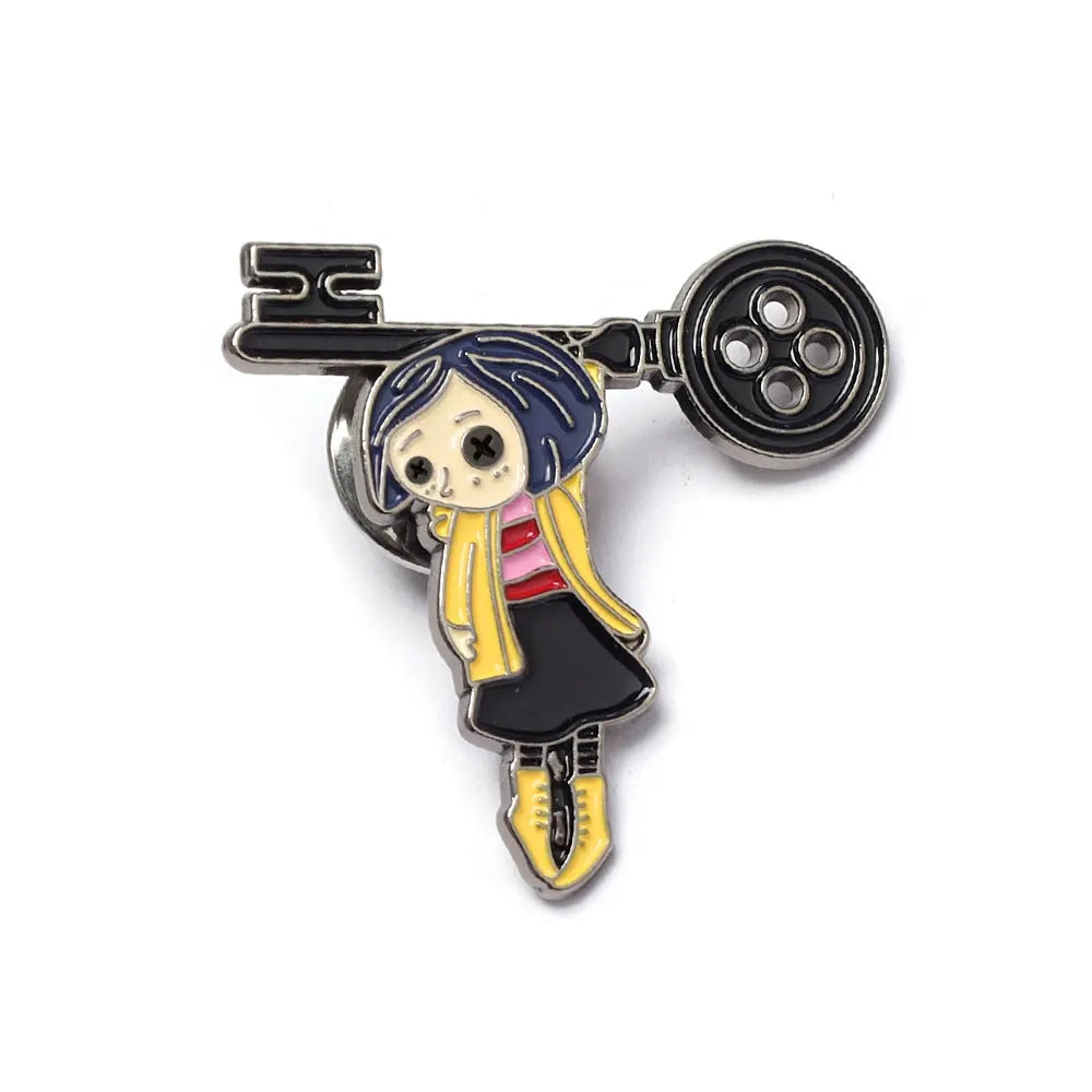 Broche émail noire représentant une fille de dessin animé aux cheveux foncés et un foulard rose, fixée à une barre d'argent.