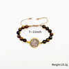 A set of brown beads and a gold medal charm bracelet with a leather cord.