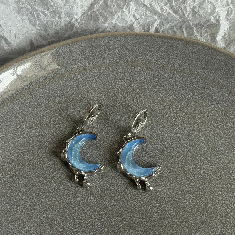 Pair of stainless steel hoop earrings shaped like crescent moons with a blue iridescent finish