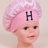 Pink satin sleep cap for kids with a black letter H