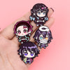 A hand holds a set of eight cute enamel cartoon brooches featuring anime-style characters.