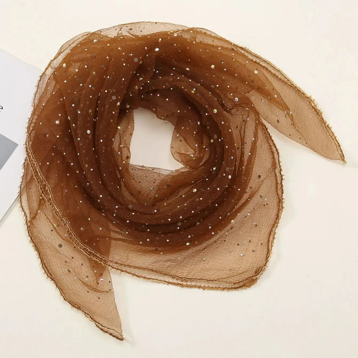 Durchsichtiger brauner Netz-Hijab mit kleinen Pailletten, in einem Wirbel gebunden.