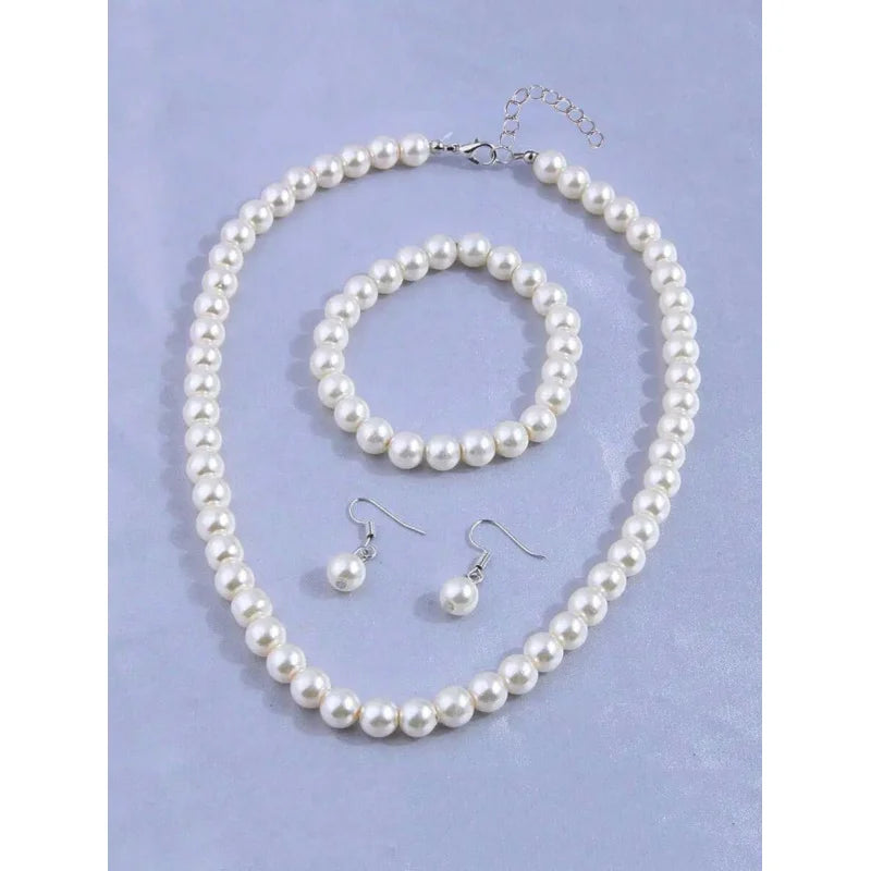 A 4-piece faux pearl jewelry set featuring a necklace and earrings displayed on a light purple background.