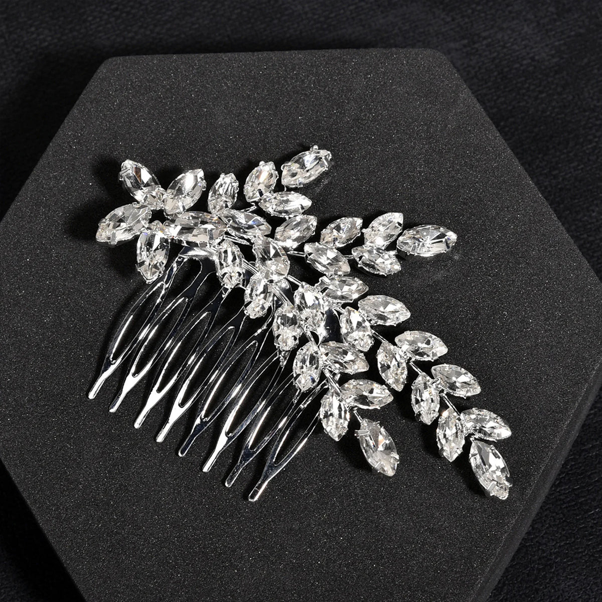 Peigne pour cheveux de mariée en cristal délicat avec des cristaux clairs en forme de feuille scintillants.