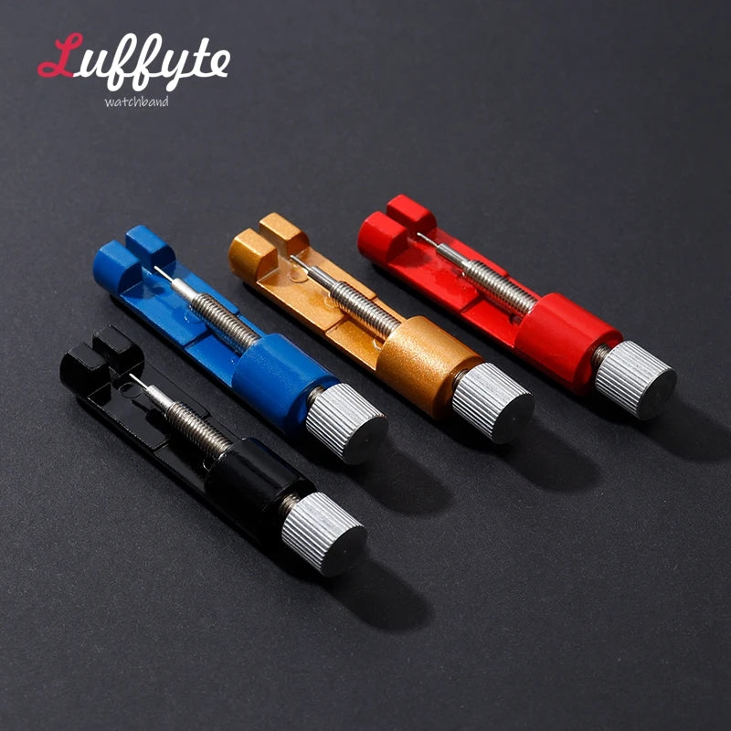 Three watchband repair tools in blue, gold, and red are displayed against a dark background.