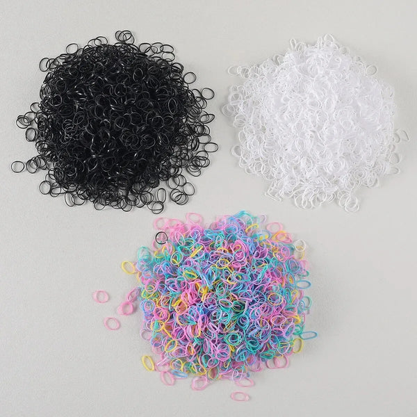 A collection of black, white, and multi-colored disposable rubber hair ties.