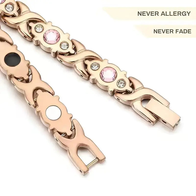 A close-up of a gold-toned geometric energy bracelet with pink and clear stones.