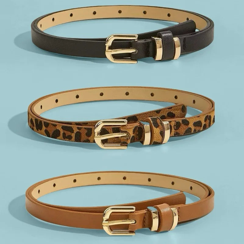 A set of three belts in black, leopard print, and tan leather with gold-toned vintage buckles.