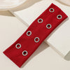 A red punk style metal hollow headband with silver grommets shown on a white surface.