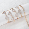 Gold-toned heart-shaped waist chain body jewelry displayed on a white fabric background.