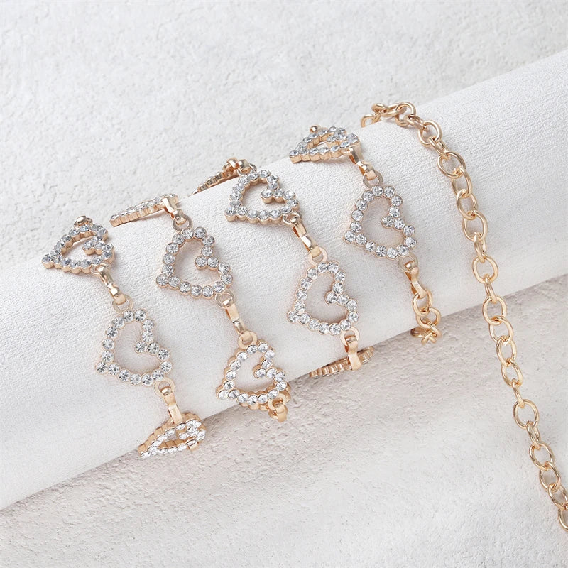 Gold-toned heart-shaped waist chain body jewelry displayed on a white fabric background.