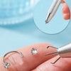 Stainless steel horseshoe nose studs with ball grabbers shown on a finger.