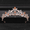 A sparkling crystal rhinestone bridal tiara headpiece featuring rose-gold accents and orange-toned stones.