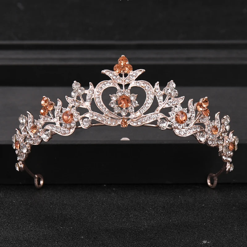 A sparkling crystal rhinestone bridal tiara headpiece featuring rose-gold accents and orange-toned stones.