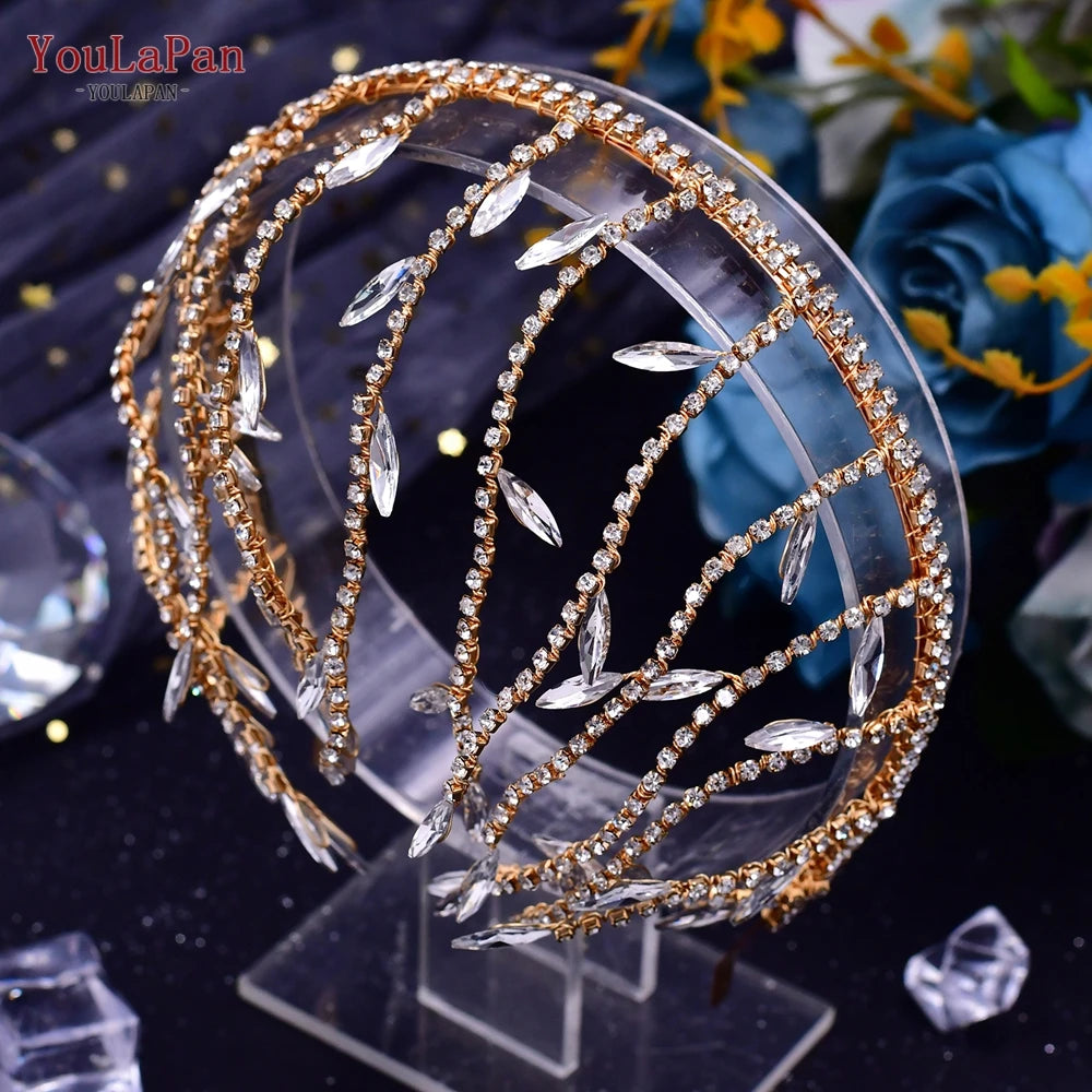 Gold-Kristall-Strass-Brauthaube mit blauen Rosen auf klarem Ständer.