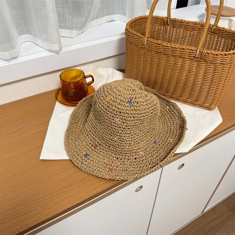 Sombrero de paja panameña tejido a mano sobre una superficie de madera junto a una canasta tejida y una taza.