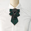 A white dress shirt with a dark green tie featuring diamond and black embellishments