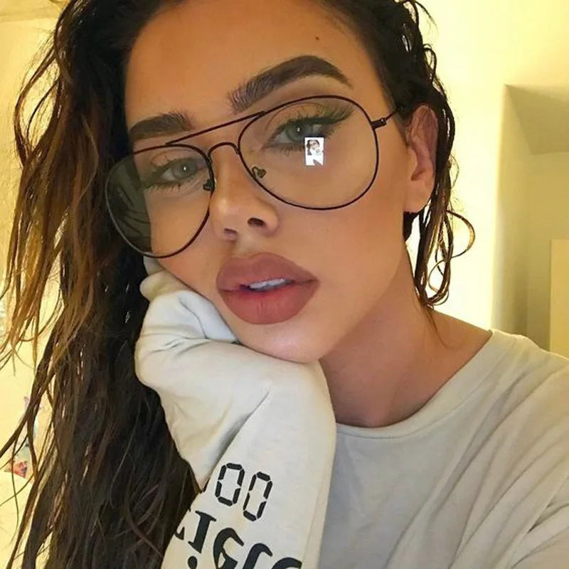 Gros plan d'une femme portant des lunettes à monture dorée rétro.