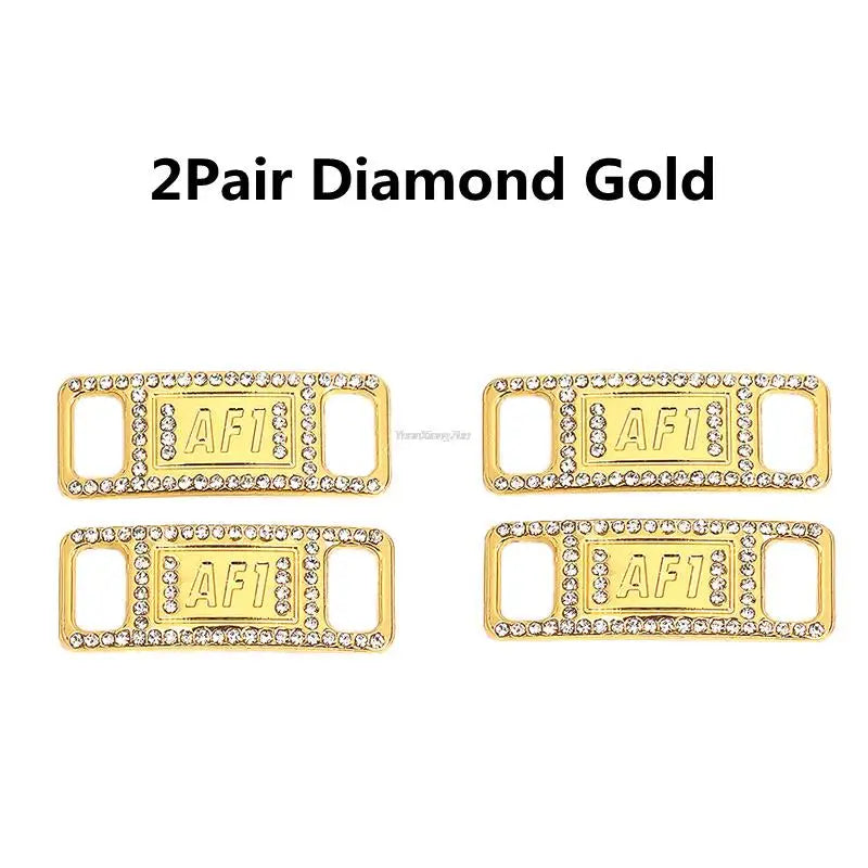 A pair of gold diamond shoe charms and laces labeled AF1