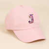 A pink baseball cap featuring a purple and white unicorn letter design.