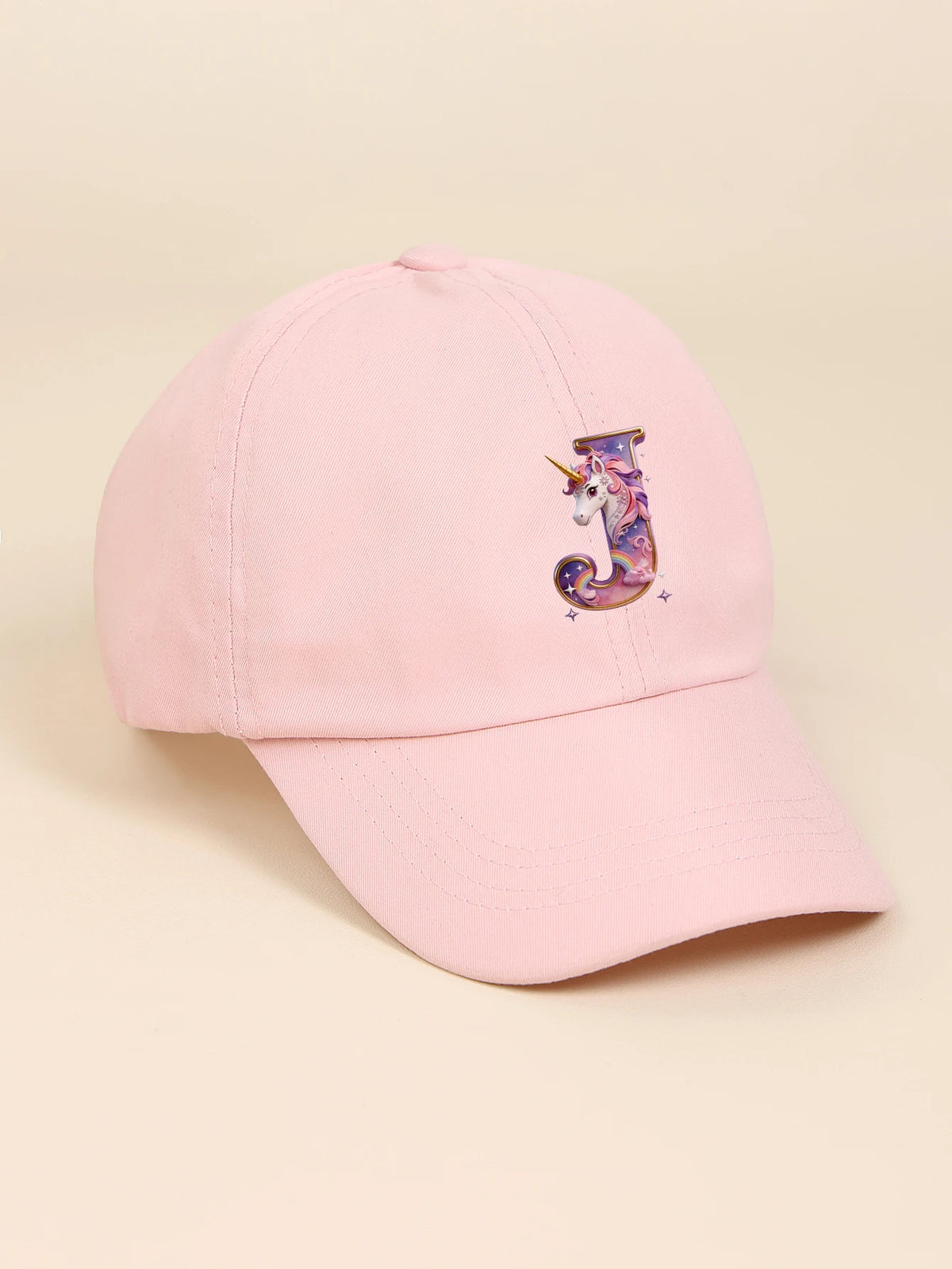 A pink baseball cap featuring a purple and white unicorn letter design.