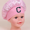 Pink sleep cap for kids with a black letter C embroidered on the front