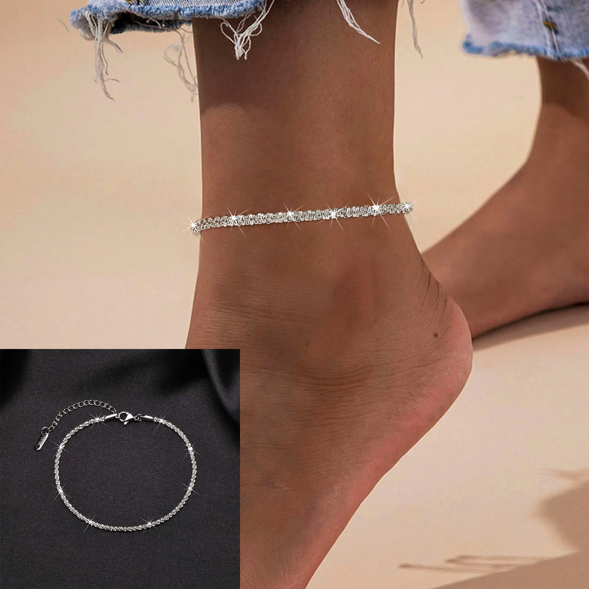 Silver snake chain anklet worn on a woman's ankle against a light background.